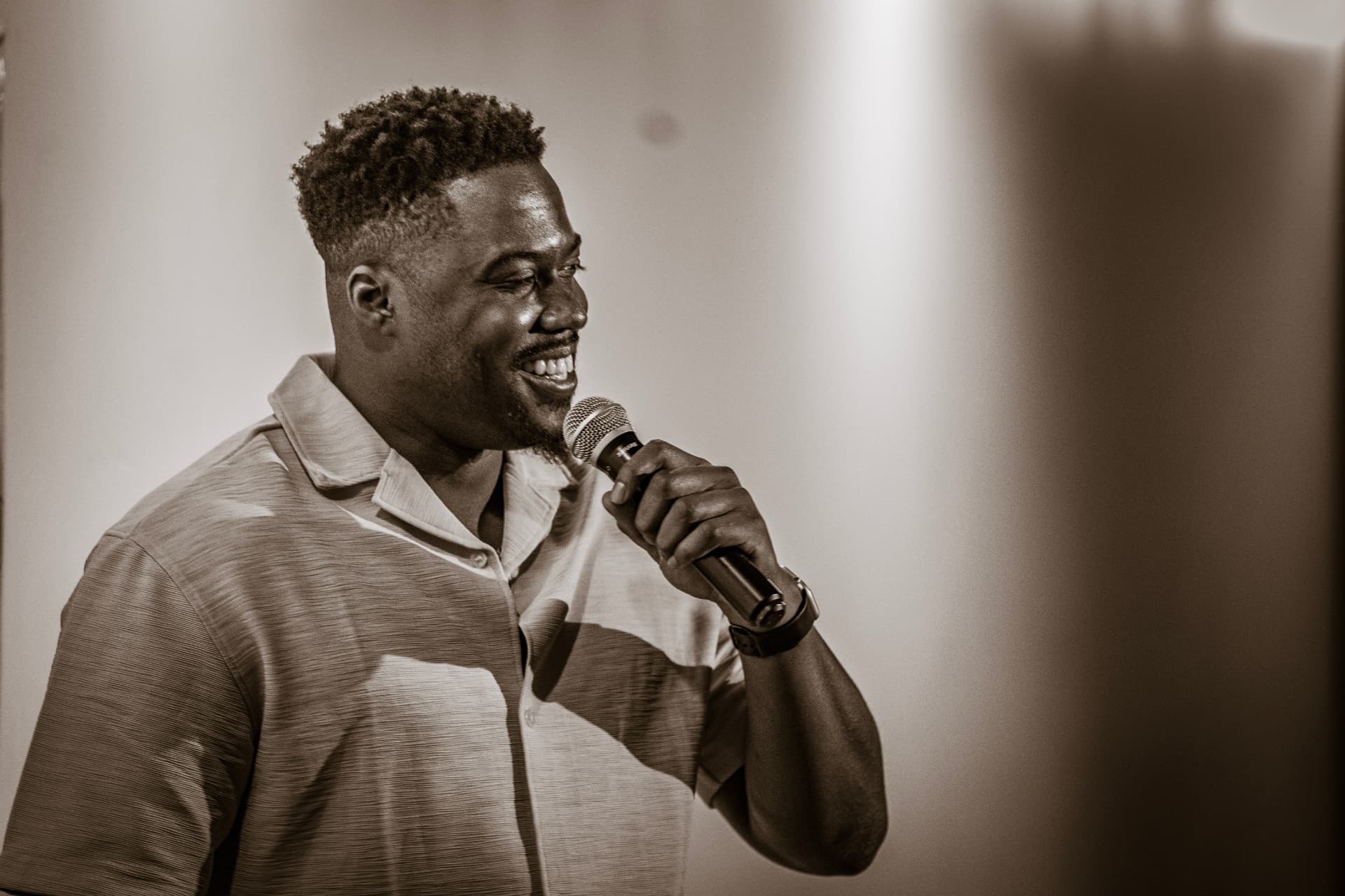 Sepia portrait of a comedian laughing into the mic