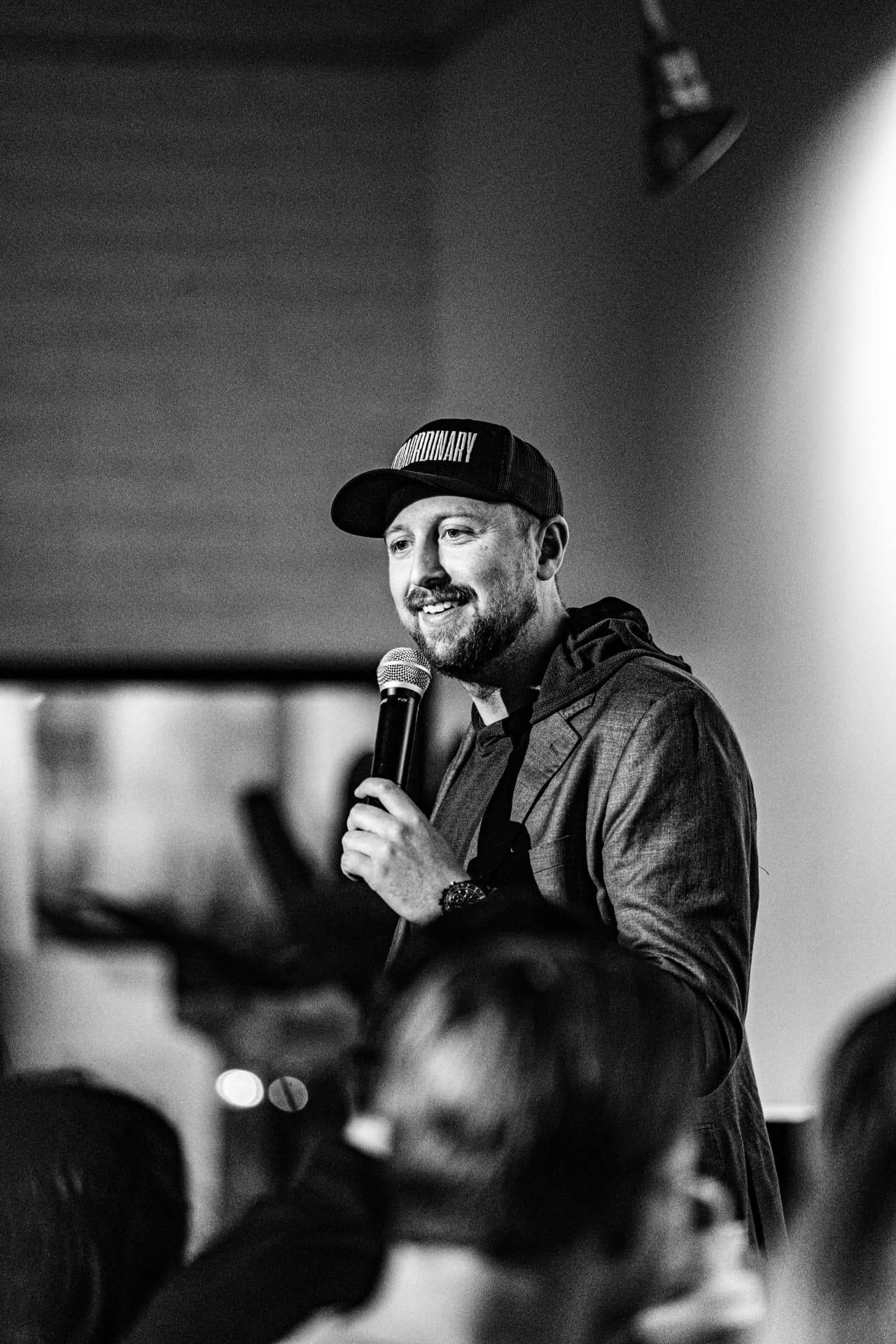 Black and white shot of the host on the mic