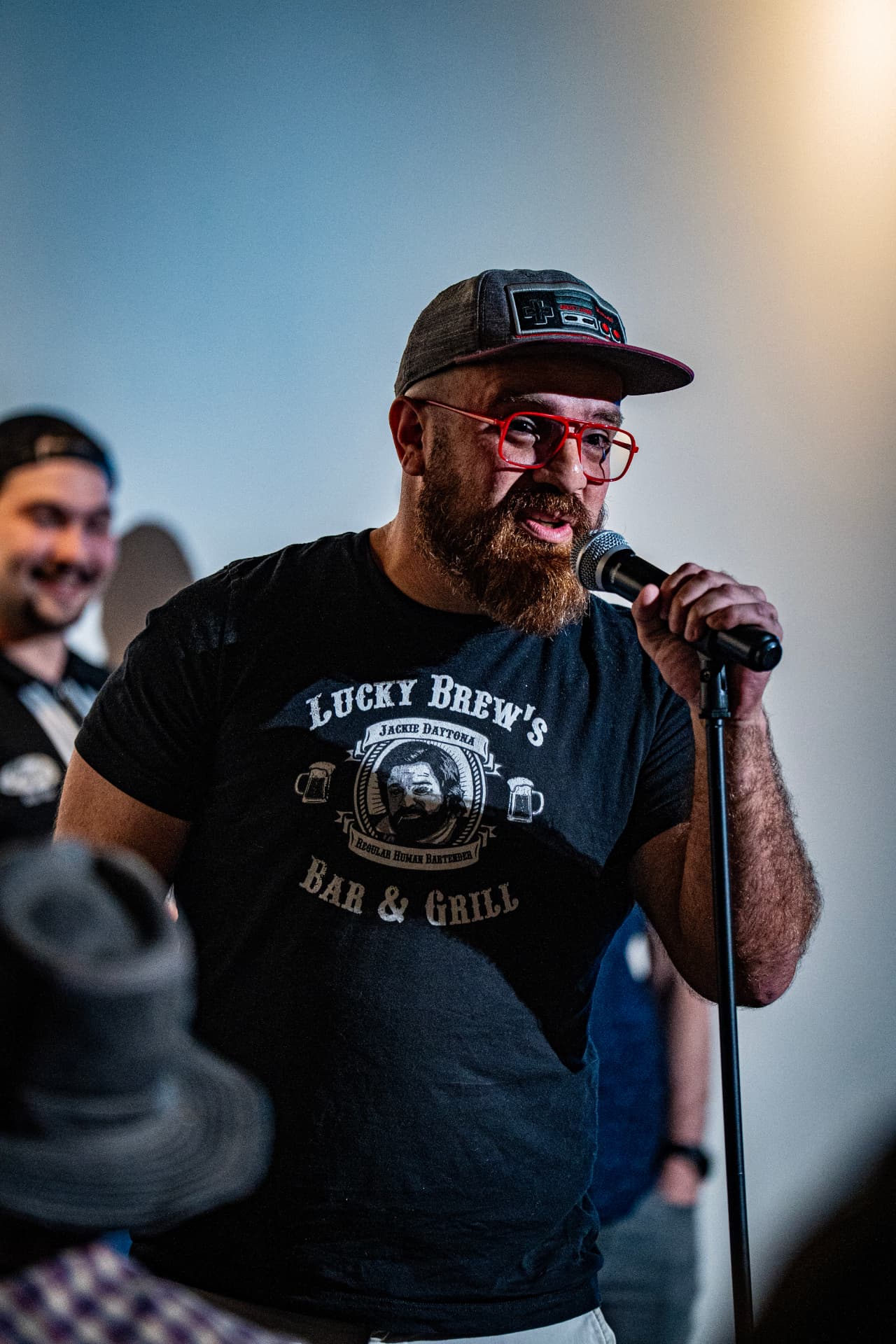 Host in red glasses hyping the room at Arizona After Dark