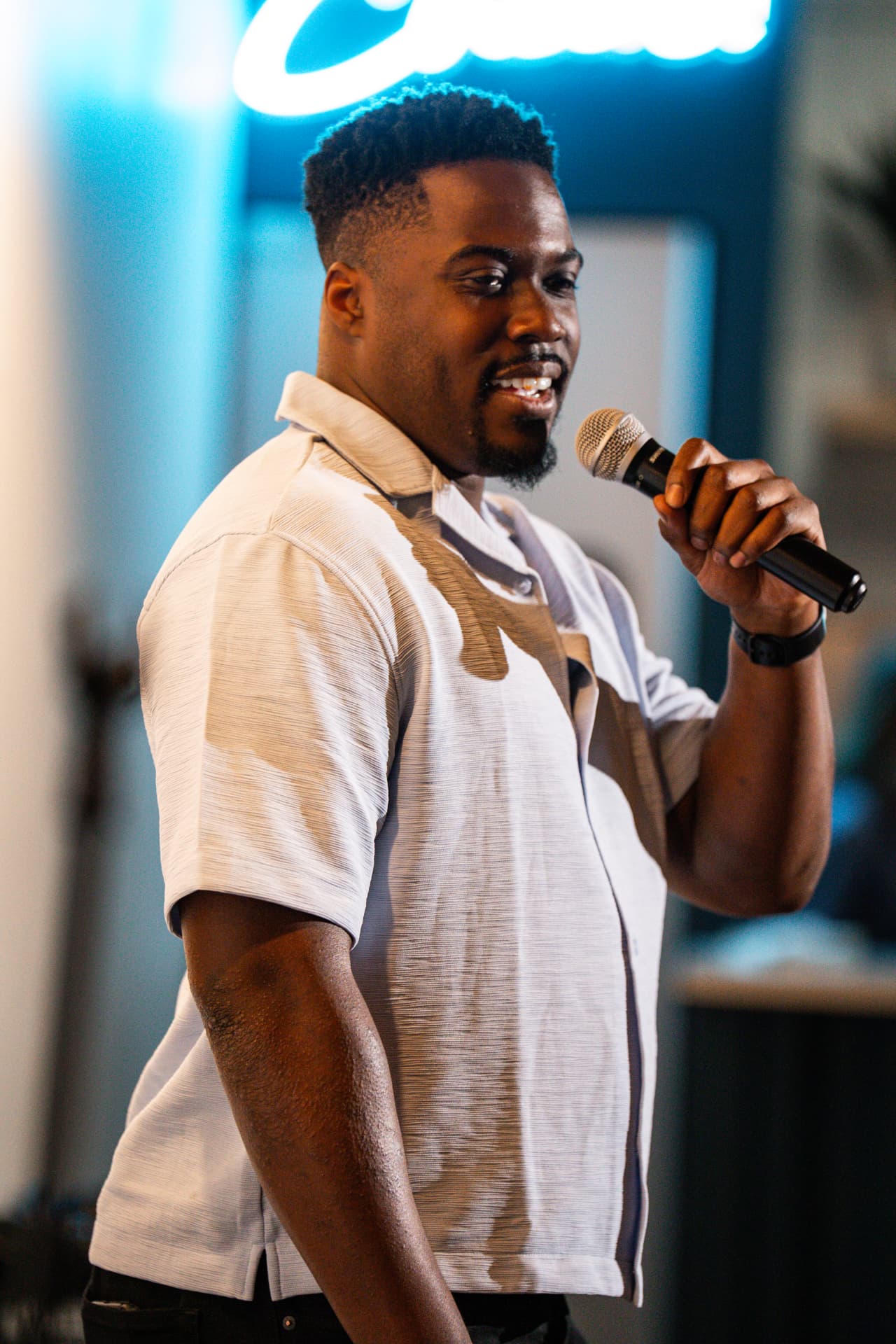 Comedian on stage under the blue neon glow